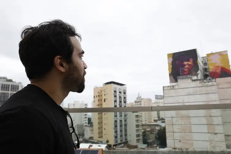 Rio de Janeiro (RJ), 18/12/2025 –  Augusto Kesrouani Nascimento observa novo mural em homenagem ao seu pai, o cantor Milton Nascimento, pintado pela artista visual Gugie Cavalcanti, inaugurado na Lapa. Foto: Fernando Frazão/Agência Brasil
