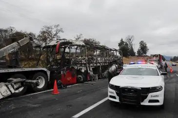 A burnt bus stands as members of the National Guard stand at the site on the highway connecting Mexico City with the state of Puebla, following roadblocks and arson attacks carried out by members of organized crime in several states after a military operation in which a government source said Mexican drug lord Nemesio Oseguera, known as 